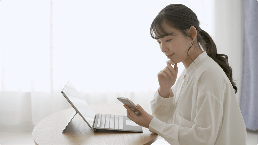 動画を見ながらPCで作業する女性